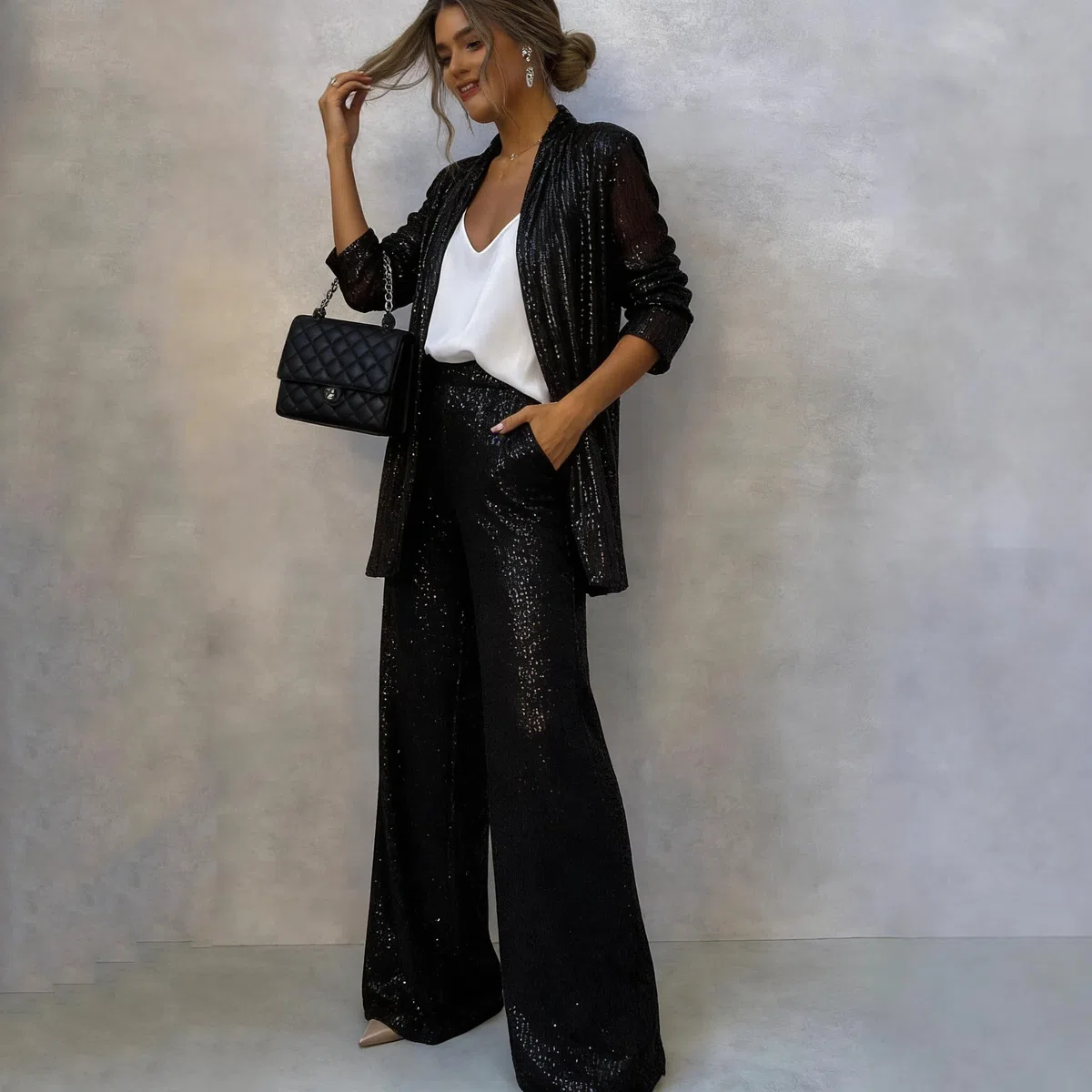 Completo da donna con paillettes composto da un elegante blazer con scollo a V e pantaloni a vita alta e gamba larga, un scintillante completo da festa in due pezzi.